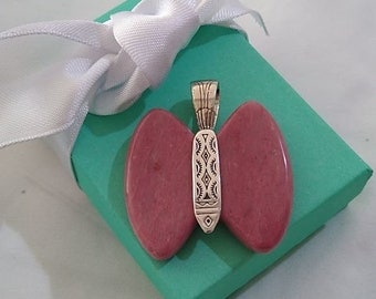 May include: A pink butterfly pendant with a silver filigree design. The pendant is in a turquoise gift box with a white ribbon.