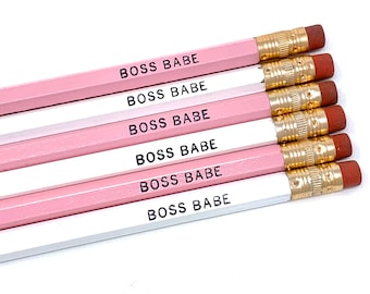 May include: Six pink and white pencils with gold accents. Each pencil has the text "BOSS BABE" printed on it.