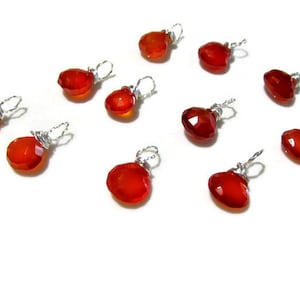 May include: Ten red carnelian gemstone pendants with silver wire wraps. The carnelian stones are faceted and have a reddish-orange color.