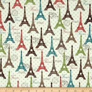 May include: A white fabric with a repeating pattern of Eiffel Towers in various colors, including brown, red, blue, and green. The towers are outlined in black and have the words "Paris" and "France" printed on them. The background is a light blue with white polka dots.