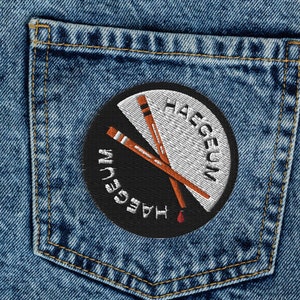 Pode incluir: Jeans azul denim com um bolso traseiro que apresenta um remendo circular com o texto "Haegeun" em branco e um design vermelho e branco de dois pauzinhos cruzados.