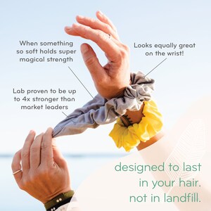 May include: Two hair scrunchies, one gray and one yellow, are shown on a person's wrist. The text "Looks equally great on the wrist!" is above the scrunchies. The text "designed to last in your hair. not in landfill." is below the scrunchies.