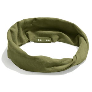 May include: An olive green headband made from soft material. The headband features a twisted design and a small, rectangular detail with three small, white dots. This accessory is designed to keep hair out of the face during workouts or everyday activities.