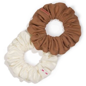 May include: Two fabric scrunchies, one brown and one white. The brown scrunchie has the word "KOOSHOO" printed on it.