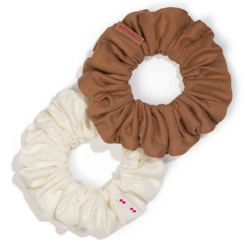 May include: Two fabric scrunchies, one brown and one white. The brown scrunchie has the word "KOOSHOO" printed on it.