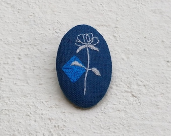 Blue brooch with flower pattern and blue detail