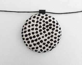 Oversized necklace in upholstery fabric, round pendant with black polka dots on a beige background