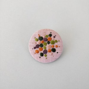 Brooch with embroidery style colored pearls on pink background image 6