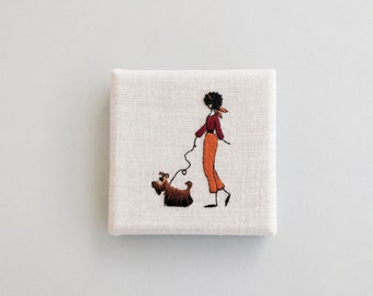Embroidered frame of a girl and her dog, back finish in coated fabric