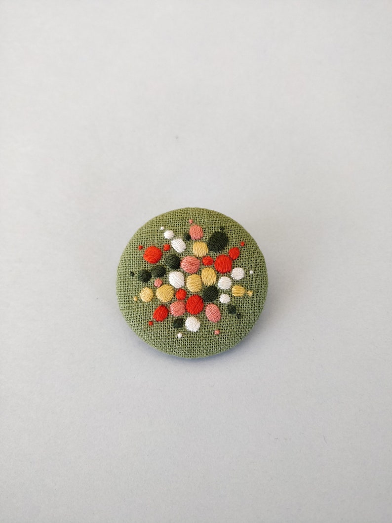 Brooch with embroidery style colored pearls on a light green background image 6