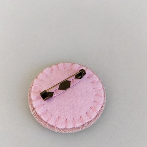 Brooch with embroidery style colored pearls on pink background image 7