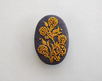 Large baroque pattern brooch, yellow embroidery brooch on gray linen