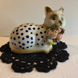 6” porcelain kitty cat laying on crochet rug doily