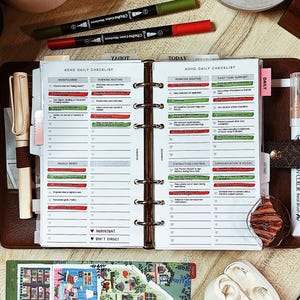 May include: A planner with an ADHD daily checklist, colour markers, and a small illustrated notebook. The planner is brown with white paper and a metal binder. The markers are green and red.