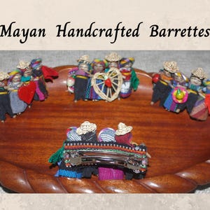 May include: Mayan Handcrafted Barrettes featuring colorful, handmade figures of people wearing traditional clothing. The barrettes are made of wood and fabric and are perfect for adding a touch of culture to your hair.