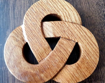 May include: A wooden knot sculpture with a brown finish. The knot is intricately carved and has a three-dimensional design.