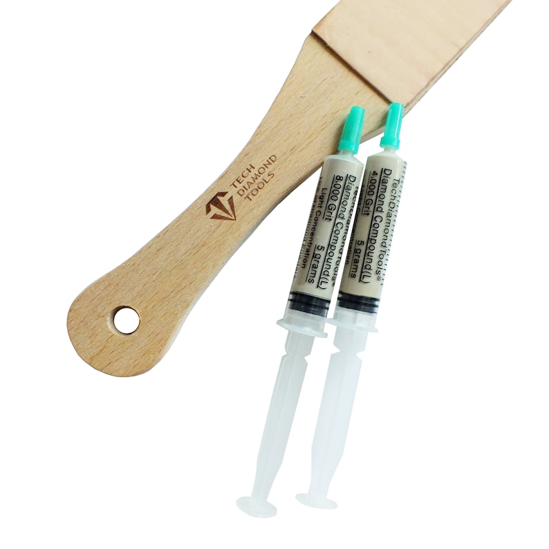 May include: A light-colored wooden strop with a logo and two syringes of diamond compound. The syringes are labeled with grit sizes of 4,000 and 8,000, each containing 5 grams of compound. The strop is for sharpening tools.