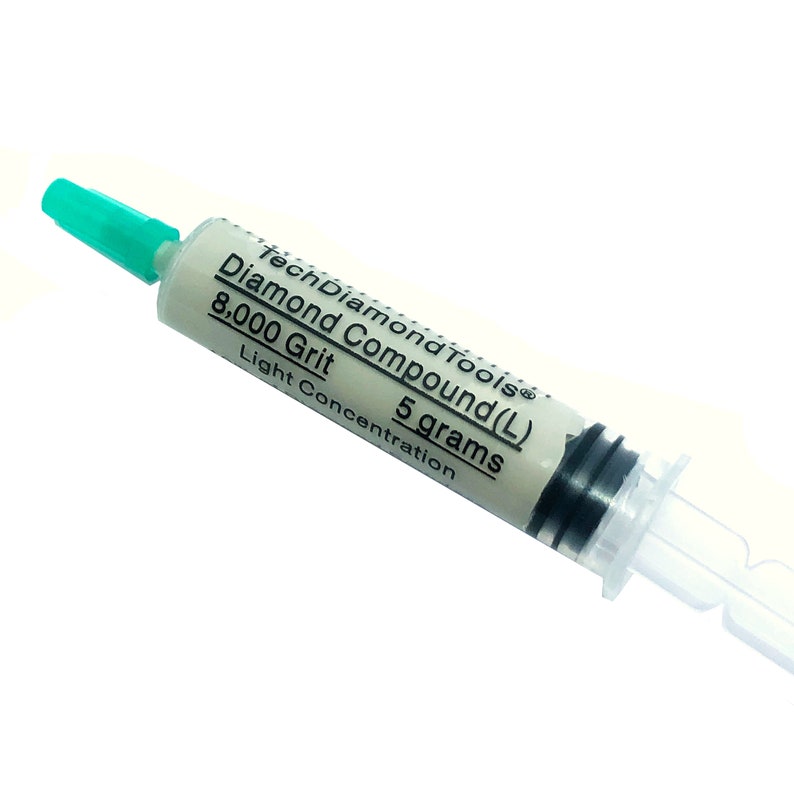 May include: A syringe of TechDiamondTools Diamond Compound (L) 8,000 Grit, 5 grams. The syringe has a white body with black markings and a green tip. The text on the syringe reads "Diamond Compound (L) 8,000 Grit 5 grams Light Concentration."