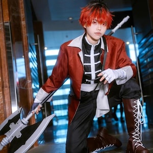 May include: A person in a cosplay outfit, kneeling and holding a large axe. The outfit includes a red jacket, black trousers, and brown boots. The person has red hair and is wearing white gloves.