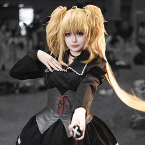 May include: A cosplay outfit featuring a black dress with a white collar and a gray corset with red lacing. The outfit includes a blonde wig styled in pigtails. The person is holding a black ring with a white X.
