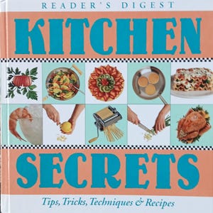 May include: A cookbook titled "Kitchen Secrets" by Reader's Digest with a teal and orange cover. The cover features a collage of images of food preparation and cooking, including a shrimp, a lemon, a pasta maker, a knife, a roasted chicken, a fruit tart, a pan of pancakes, a wok of stir-fry, and a lasagna. The text "Tips, Tricks, Techniques & Recipes" is printed below the title.