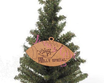 May include: A brown wooden football ornament with a football play diagram and the text "The Philly Special".