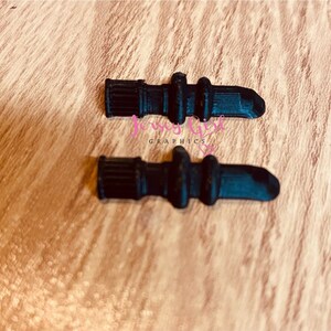 Pode incluir: Duas pontas de pl&aacute;stico preto para uma caneta 3D. As pontas s&atilde;o cil&iacute;ndricas com uma extremidade arredondada e uma superf&iacute;cie texturizada.