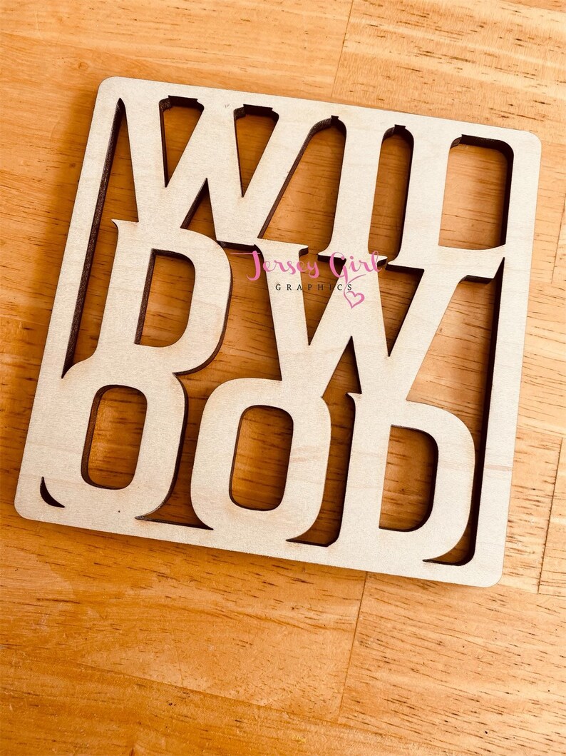 May include: Wooden sign with the word "WOOD" cut out in a decorative font. The sign is light brown and has a slightly distressed look.