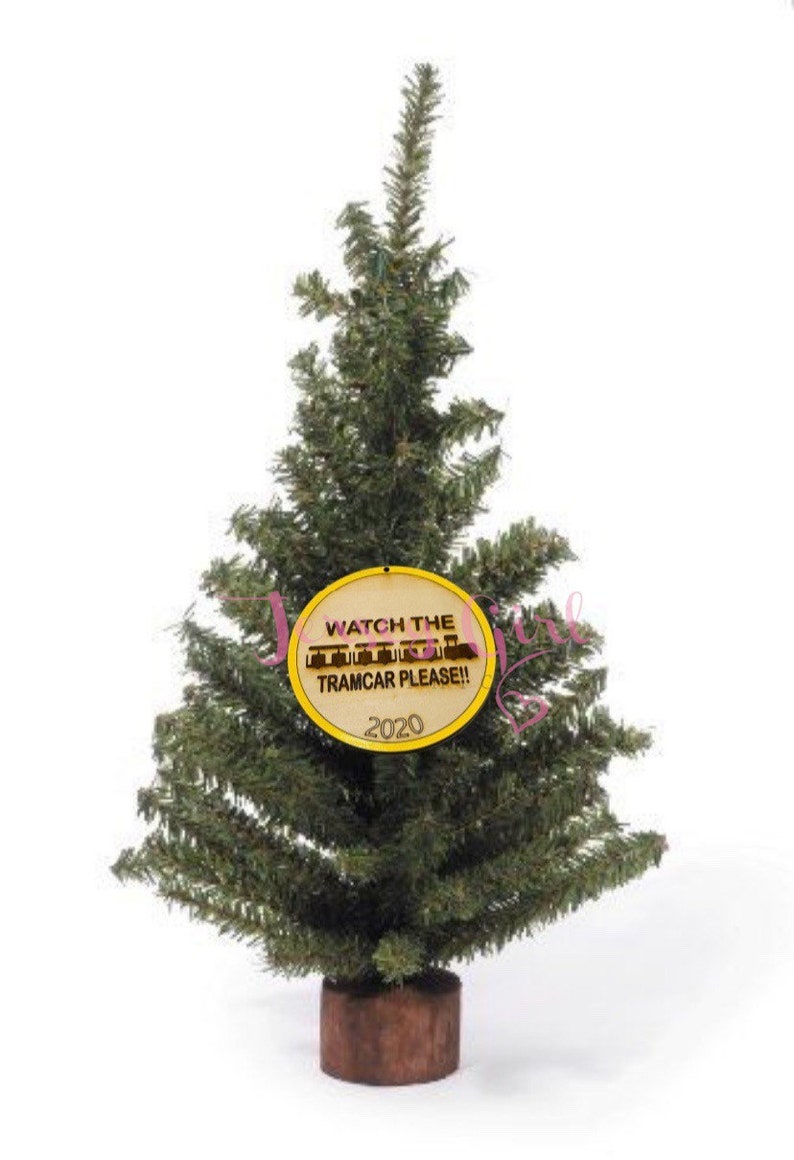 Puede incluir: Un peque&ntilde;o &aacute;rbol de Navidad artificial con un adorno redondo amarillo que dice "Watch the Tramcar Please!" y "2020".
