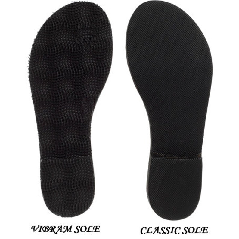 May include: Two black shoe soles are displayed side by side against a white background. The left sole is labeled "VIBRAM SOLE" and has a textured, grid-like pattern. The right sole, labeled "CLASSIC SOLE", has a smooth, slightly textured surface.