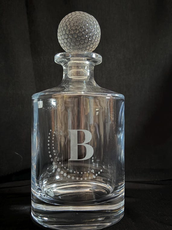 Godinger crystal golf ball decanter — the actual crystal form factor is legitimately striking and the golf motif makes it a specific, memorable retirement or golfer gift.