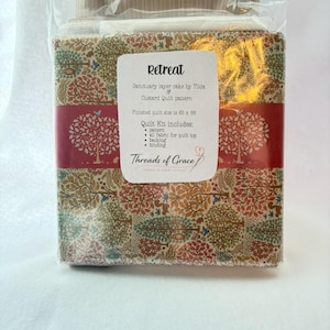 Puede incluir: Un kit de edredón en una bolsa de plástico transparente. El kit incluye tela con un estampado de árboles y pájaros, una banda roja y una etiqueta con el texto "Retreat". El tamaño final del edredón es de 211 x 224 cm.