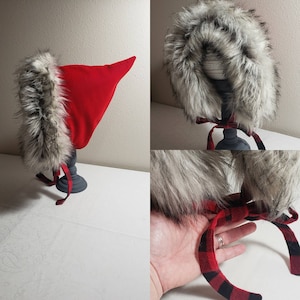 May include: Red hooded baby bonnet with a white faux fur trim and a red and black plaid ribbon tie.