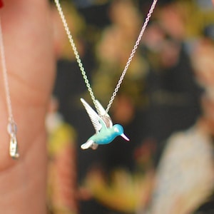 Sterling Silver and Enamel Hummingbird Necklace shown in close up as being put on.