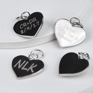 Rhodium plated heart shaped disc charms which can be engraved on one or both sides shown close up to show engraving styles. Charms are silver coloured.