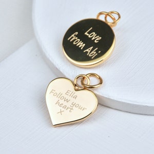 Personalised Gold Heart or Circle Disc Charm which is engraved on one or both sides. Shown close up with jump ring.