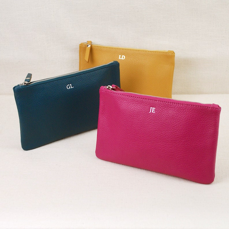 Monogram Leather Cosmetic Bags shown in fuchsia, mustard and teal.