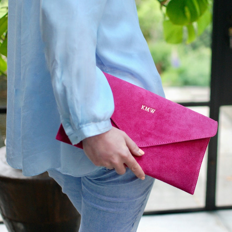 Monogrammed Suede Envelope Clutch - Fuchsia with gold foil initials shown close up with model.