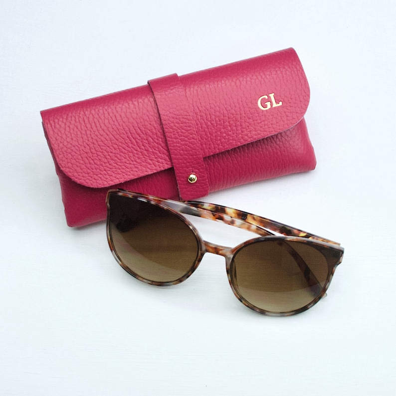 Fuchsia Personalised Leather Glasses case shown close up with model with GL monogram in gold.