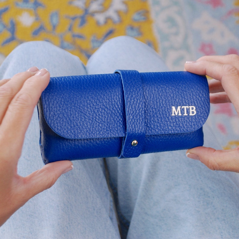 Cobalt Blue Personalised Leather Glasses case shown close up with model with MTB monogram in gold