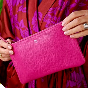 Monogram Leather Cosmetic Bag in fuchsia showing JE initials in silver close up with model.