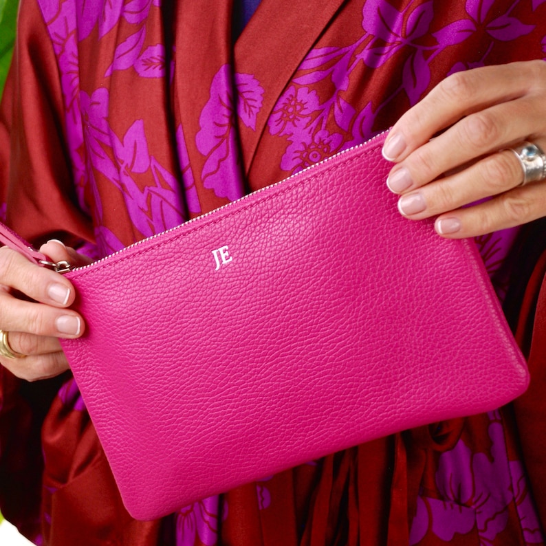 Monogram Leather Cosmetic Bag in fuchsia showing JE initials in silver close up with model.