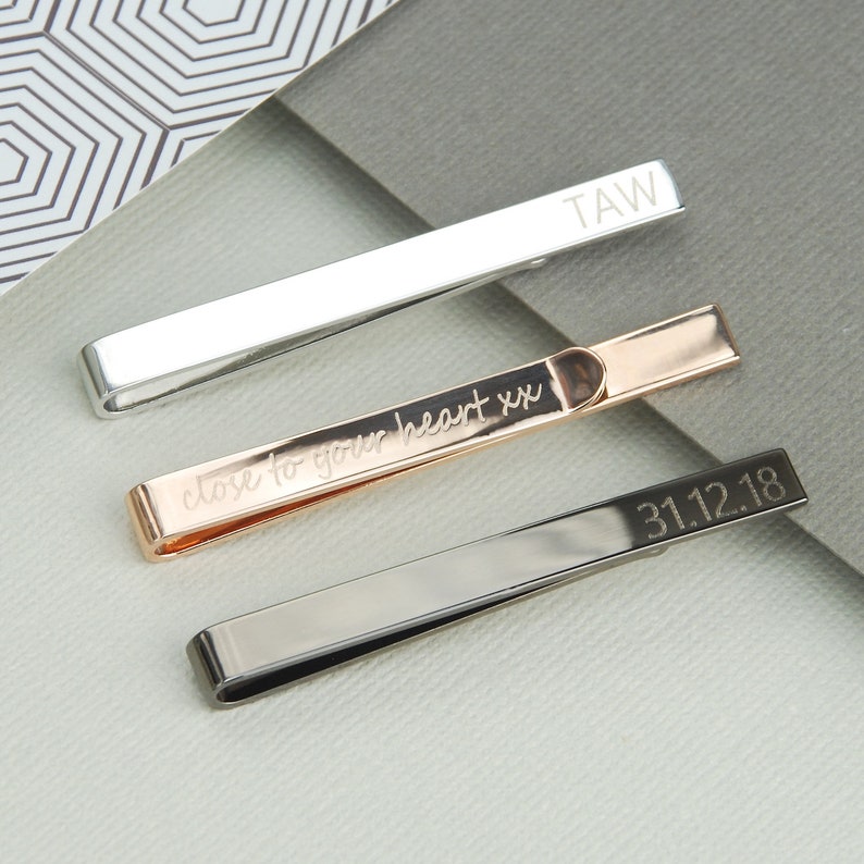 Personalised Tie Slide shown in rose gold, gunmetal and silver/rhodium plated finishes with engraving on front and back.