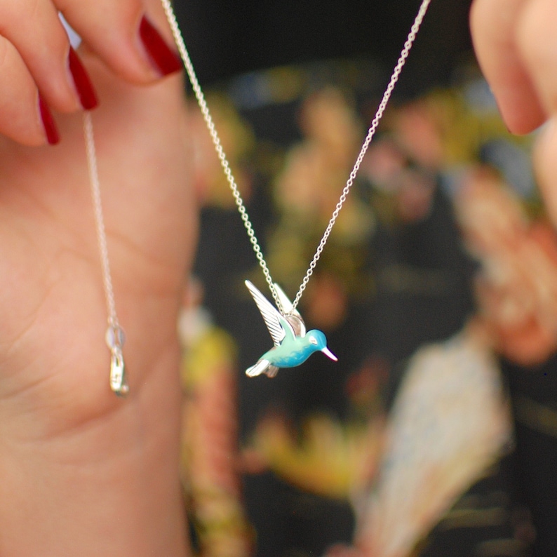 Sterling Silver and Enamel Hummingbird Necklace shown in close up as being put on.