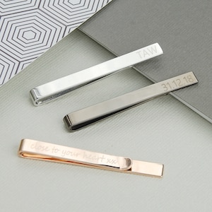 Personalised Tie Slide shown in rose gold, gunmetal and silver/rhodium plated finishes with engraving on front and back.