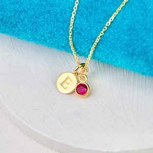Personalised Gold Initial Birthstone necklace on 18" chain shown close up. Letter E charm and pink tourmaline/October birthstone charm.