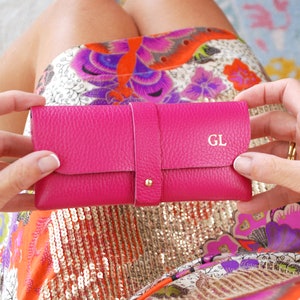 Fuchsia Personalised Leather Glasses case shown close up with model with GL monogram in gold foil.