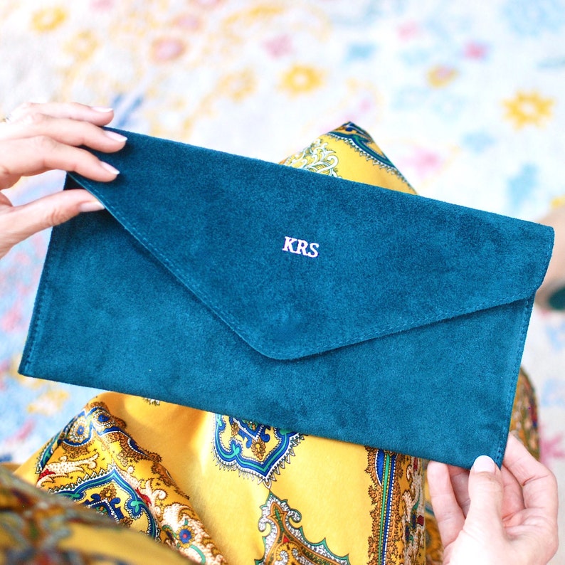 Monogrammed Suede Envelope Clutch - Teal with silver foil initials shown close up with model.