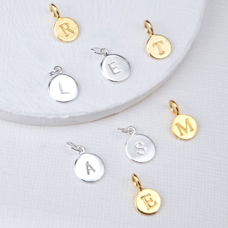 Sterling Silver and Gold plated sterling silver initial letter disc charms shown close up.
New style silver initials disc shown