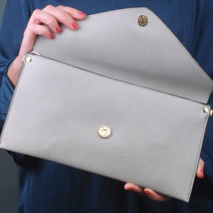 Open Monogram envelope clutch bag in light grey showing colour only